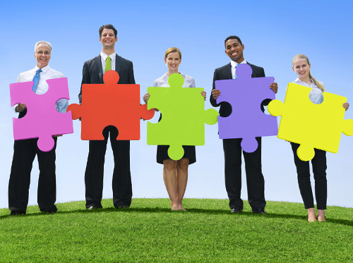 Free Coaching Exercises shown by people standing holding colourful jigsaw pieces