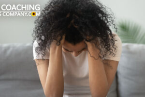 Woman sat on sofa with head in hands