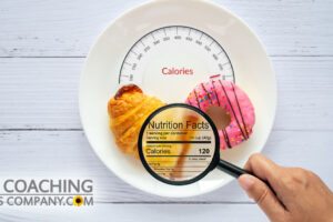 Magnifying glass on Nutrition Facts on plate with doughnut