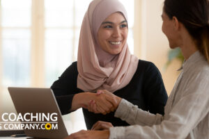 Coach and Client in Final Coaching Session coaching questions shaking hands at desk