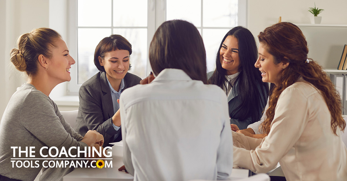 Coach and Clients sit around table for what is group coaching