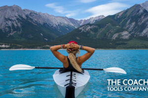 Client in kayak on lake looking at mountains for life coaching exercises