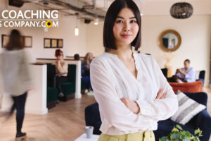 Confident Coach standing in office with arms folded