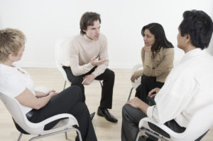 Group Coaching - 4 people sat down having a discussion