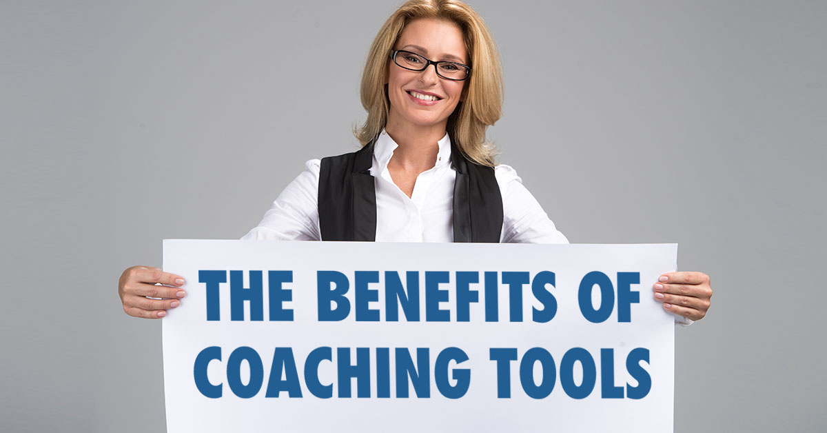 Coach holding sign that says The Benefits of Life Coaching Tools