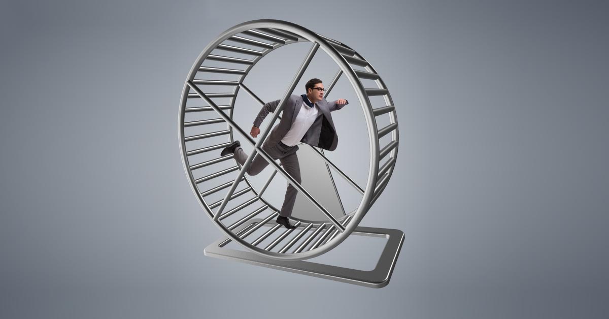 Business Man in Grey Suit Runs on Hamster Wheel