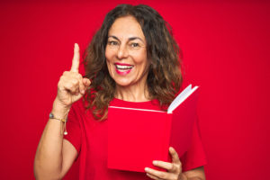 Coach Pointing Excited Reading a book on red background