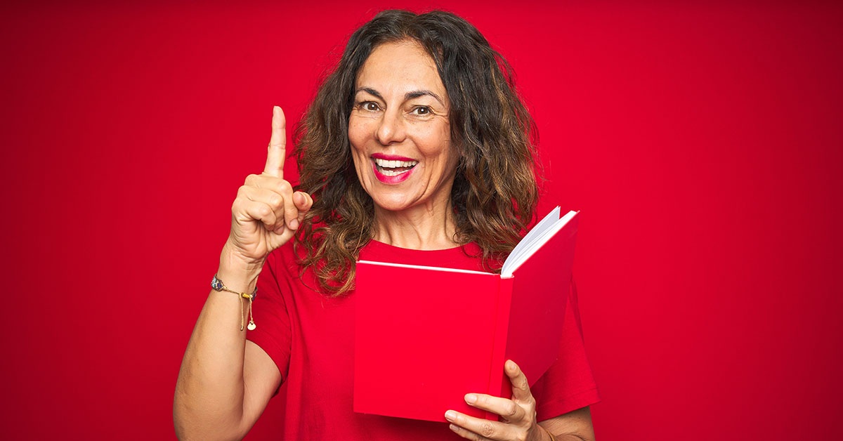 Coach Pointing Excited Reading a book on red background