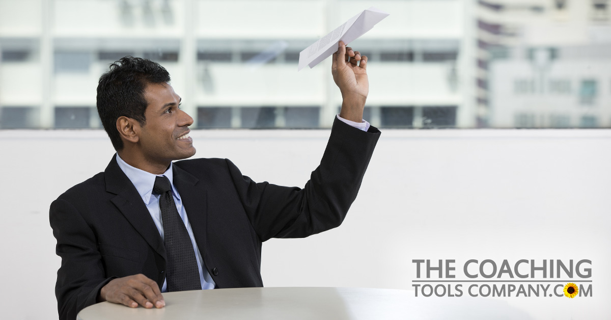 Client holding paper airplane for goals
