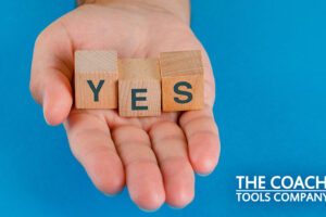 Client's Hand Saying Yes with Wooden Cubes