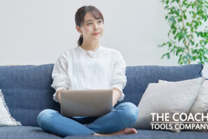 Person on sofa with laptop pausing in work for ideas and self-care