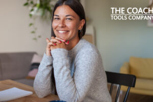 Coach Smiling at Desk considering neuroscience ideas