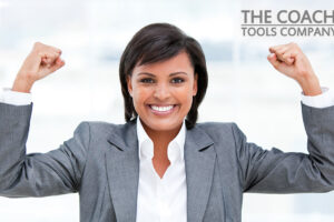 Businesswoman punching the air representing coaching questions for achieving success