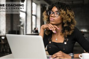 Female coach sitting thoughtfully, reflecting on personal and professional growth